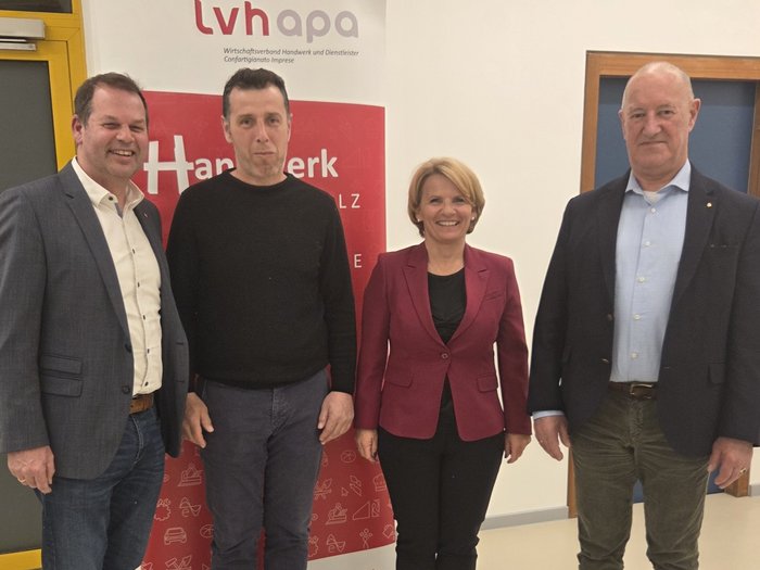 Dialog auf Augenhöhe: lvh-Ortsversammlung in Neumarkt Vier Personen vor LVH APA Banner in einem Gebäude