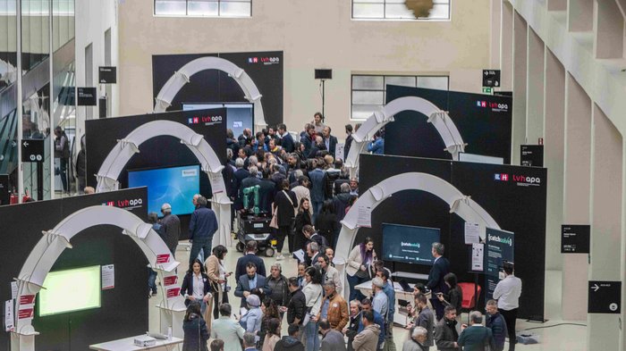 Intelligenza artigiana: nuove opportunità grazie all‘IA Visitatori a fiera o conferenza in edificio moderno con stand espositivi