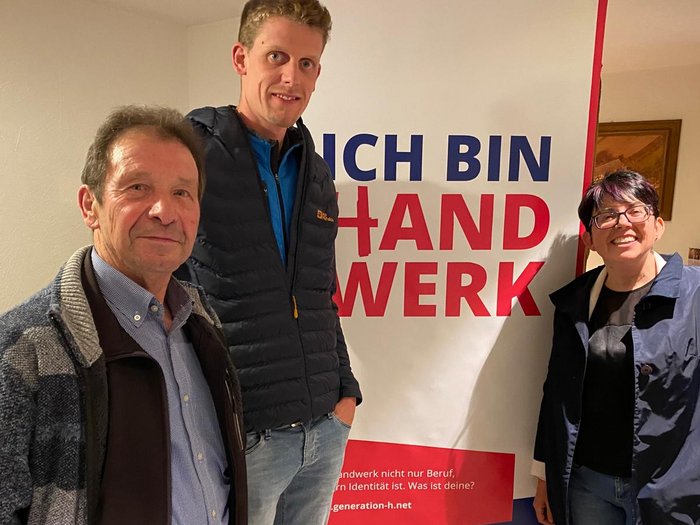 Klausen: Bezirksversammlung setzt starke Impulse Drei Personen stehen vor einem Banner mit dem Text Ich bin Handwerk