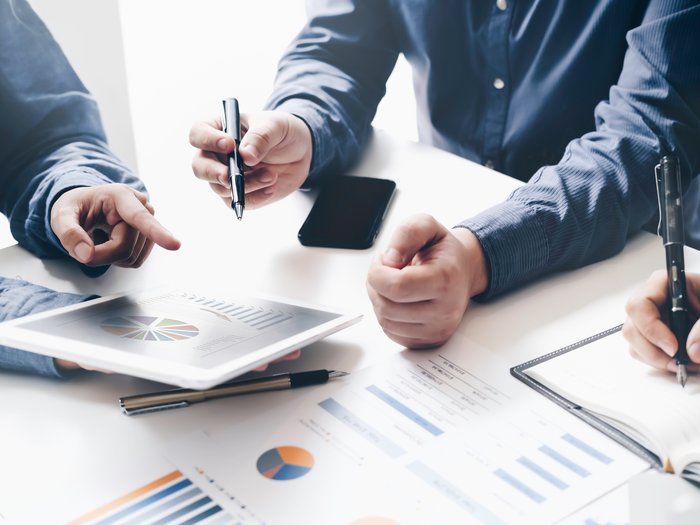 Gründertag am 26. Mai: Der lvh als Anlaufstelle für Unternehmensgründungen Team diskutiert Grafiken und Daten bei einer Besprechung am Tablet und Notizbuch