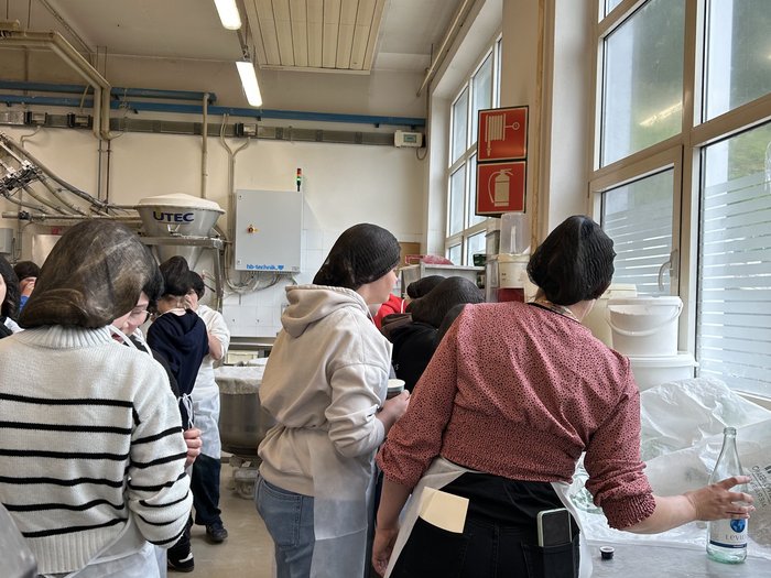 Scegliere il mestiere giusto Persone con cuffie e grembiuli in una cucina industriale o area di produzione.