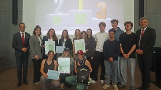 News Gruppenfoto von Preisträgern mit Auszeichnungen vor einer Bühne mit Podest 1, 2, 3