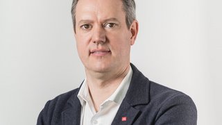 News Porträt eines Mannes mit weißem Hemd und dunklem Sakko vor weißem Hintergrund