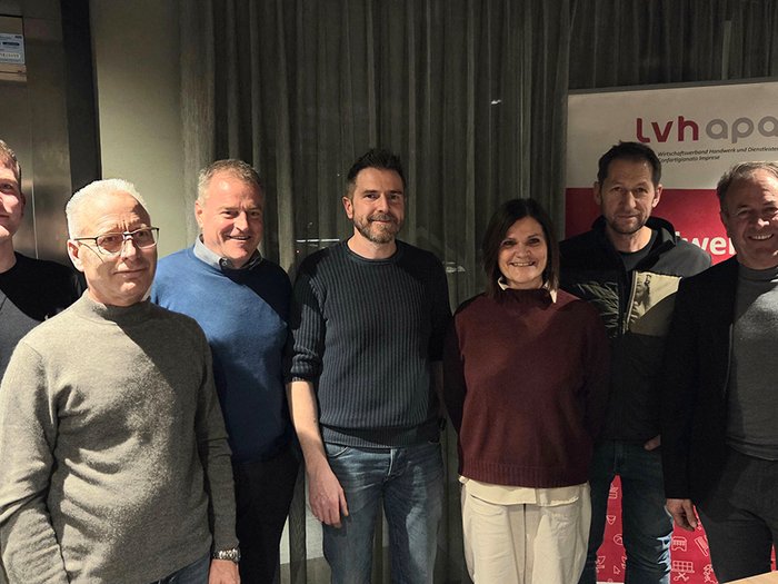 Handwerk in Deutschnofen: Mit frischen Ideen und klarer Zukunftsstrategie Gruppenfoto von sieben Personen vor einem lvhapa Banner