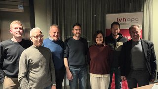 News Gruppenfoto von sieben Personen vor einem lvhapa Banner