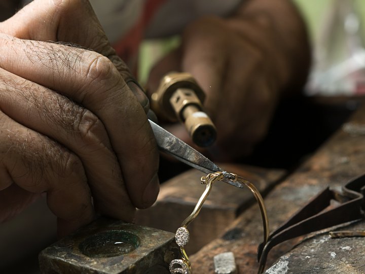 Orafi e argentieri Artigiano ripara un paio di occhiali dorati con strumenti manuali