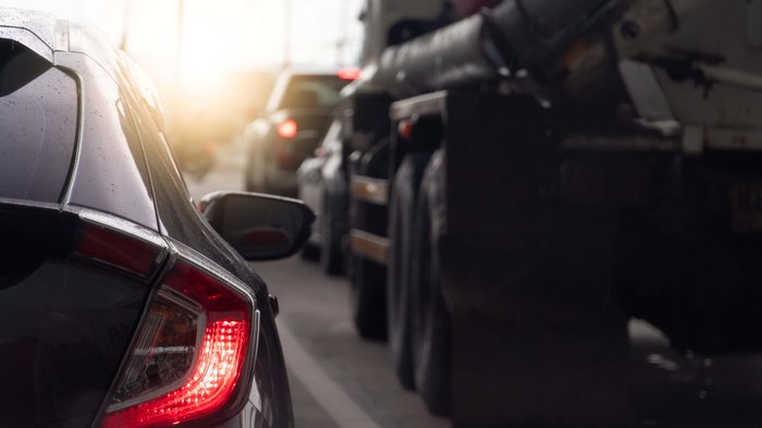 Neue Straßenverkehrsordnung in Kraft Rückansicht eines Autos im Stau mit eingeschaltetem Bremslicht bei Sonnenuntergang