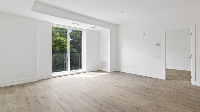 Startschuss für digitale Leerstandserhebung in allen Gemeinden Helle, leere Wohnung mit Holzboden und großen Fenstern mit Blick auf Bäume