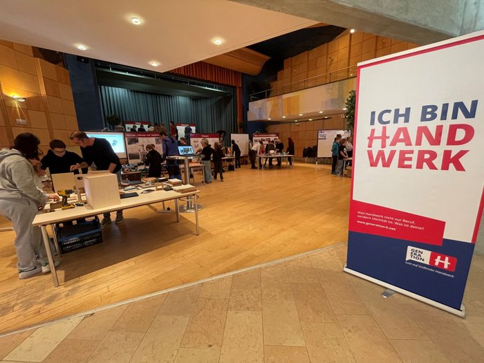 Mittelschüler mittendrin, in der Welt der praktischen Berufe Handwerksmesse mit Ständen und Menschen in einer großen Halle