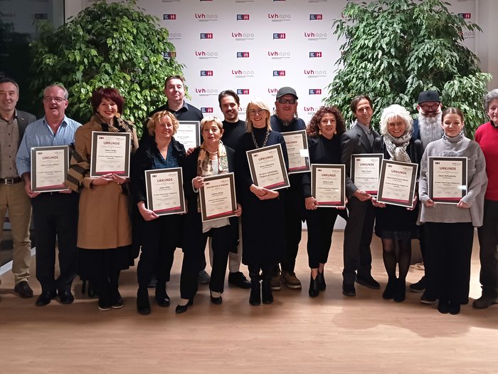 Erleichterung für die Anstellung von Lehrlingen Gruppe von 15 Personen mit Urkunden vor LVH-Hintergrund