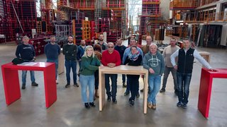 News Gruppe von Menschen in Lagerhalle mit Regalgestellen und Tischen