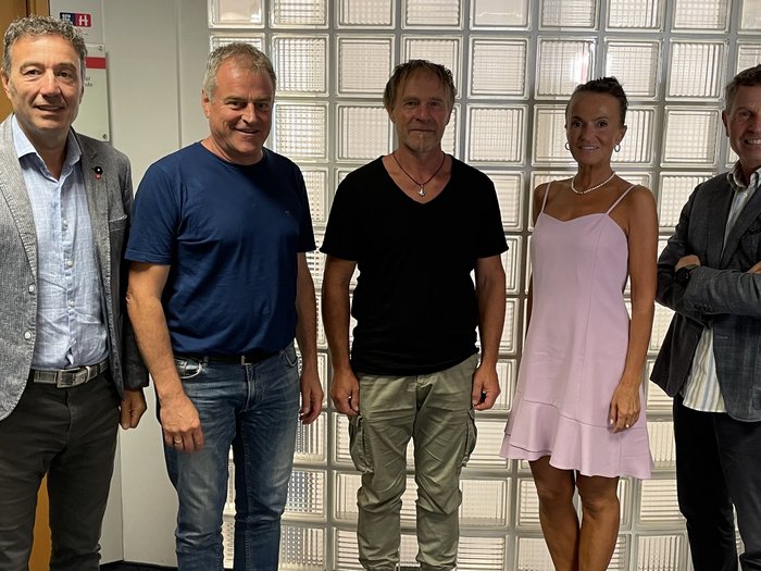 lvh setzt sich für Einsatz von Vogelschutzglas ein Fünf Personen stehen nebeneinander vor einer Glaswand in einem Büro