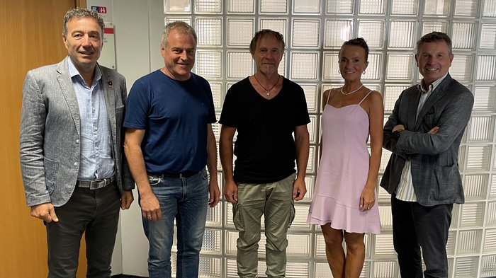 lvh setzt sich für Einsatz von Vogelschutzglas ein Fünf Personen stehen nebeneinander vor einer Glaswand in einem Büro