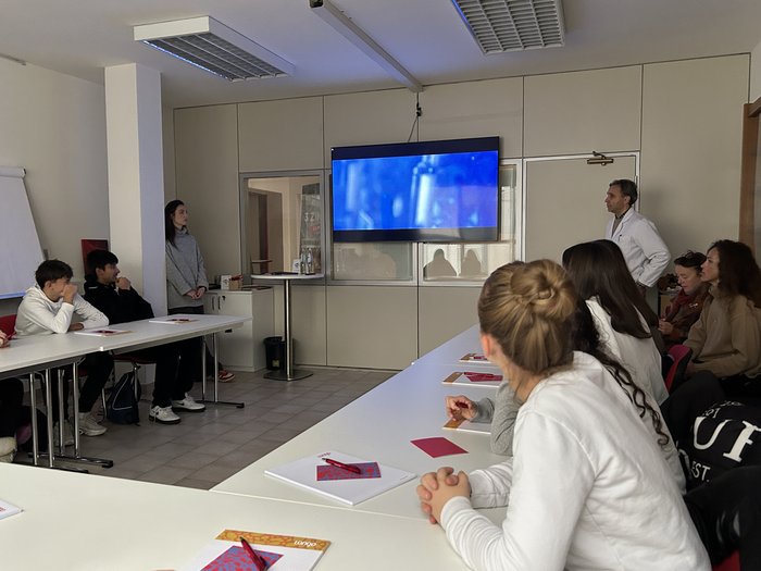 Die Handwerks- und Gastbetriebe von Bozen im Fokus Schüler und Lehrer sehen sich eine Präsentation auf einem Bildschirm im Klassenzimmer an