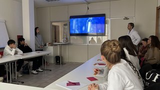 News Schüler und Lehrer sehen sich eine Präsentation auf einem Bildschirm im Klassenzimmer an