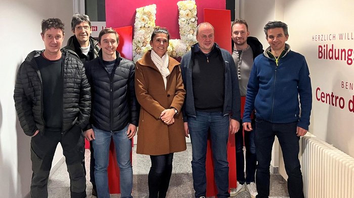 Portabici: la sospensione offre l'opportunità di una nuova regolamentazione Sette persone in piedi davanti a una scultura rossa con rose bianche