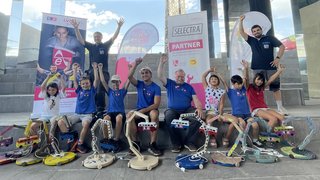 Projektwoche „Bunte Lichtermacher“: die Kinder mit den Handwerkern Herbert Kasal (links oben stehend), Alexander Morandell (rechts oben stehend), Daniel Rella und Herbert Bonora (in der Mitte sitzend). © lvh.apa Kinder und Erwachsene mit gebastelten elektrischen Lampen sitzen vor Bannern unter einem Dach