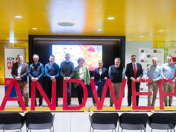 Nachwuchsinitiative „Abenteuer Handwerk“ der Intercable Arena Gruppenfoto von zehn Personen hinter roten Buchstaben, die #HANDWERK bilden