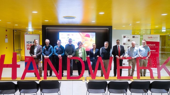 “Avventura artigianato”: l'iniziativa per i giovani talenti all'Intercable Arena di Brunico Foto di gruppo di dieci persone dietro le lettere rosse con la scritta #HANDWERK