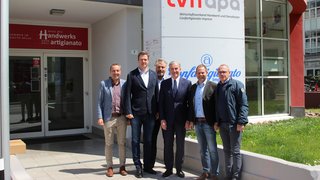 News Sechs Männer stehen vor dem Gebäude des Handwerksverbands LVH APA