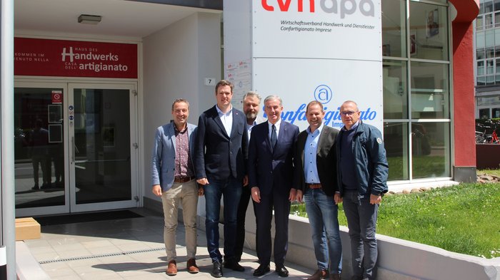 Besonderer Besuch im lvh Sechs Männer stehen vor dem Gebäude des Handwerksverbands LVH APA