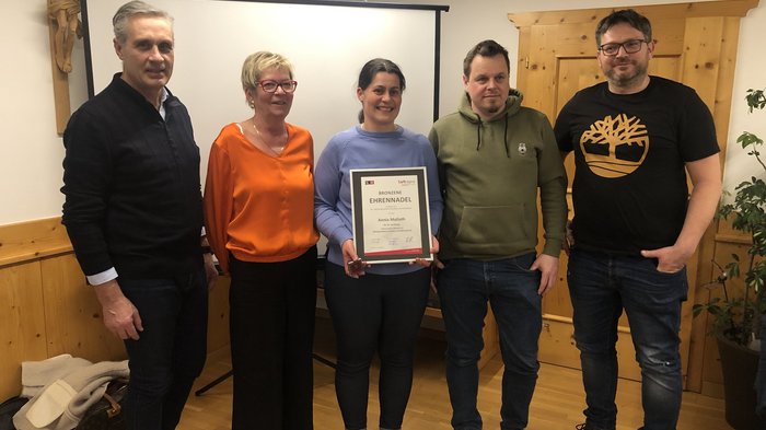 Wir sind Handwerk! Fünf Personen in einem Raum, eine hält eine Urkunde und Auszeichnung