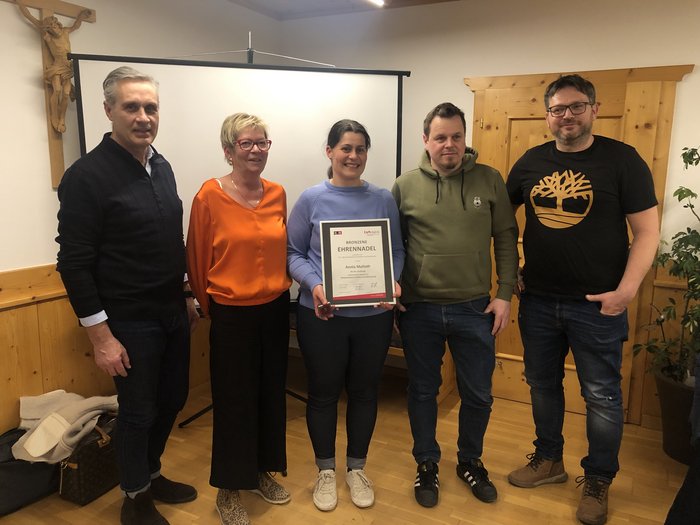 Wir sind Handwerk! Fünf Personen in einem Raum, eine hält eine Urkunde und Auszeichnung