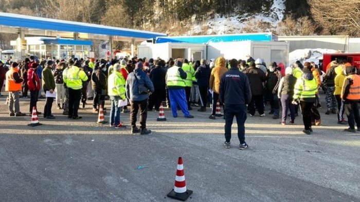Extremzustände für Lkw-Fahrer Menschenmenge vor mobilen Gebäuden in bergiger Landschaft im Winter