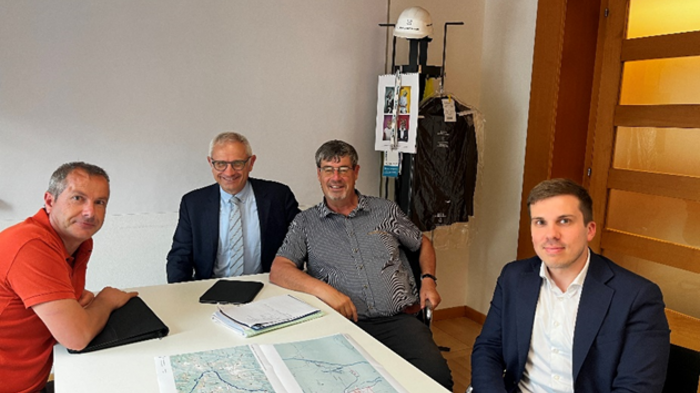 Aussprache zur Reschenbundesstraße: Alternativrouten und Sanierungspläne im Fokus Vier Männer in einem Büro sitzen am Tisch mit Karten und Notizen