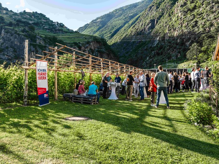 Consegna della spilla d’oro di lvh.apa Persone riunite all'aperto in una valle con montagne sullo sfondo sotto il sole
