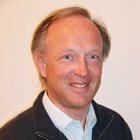 Intagliatori in legno Uomo con giacca casual e camicia sorride davanti a sfondo neutro