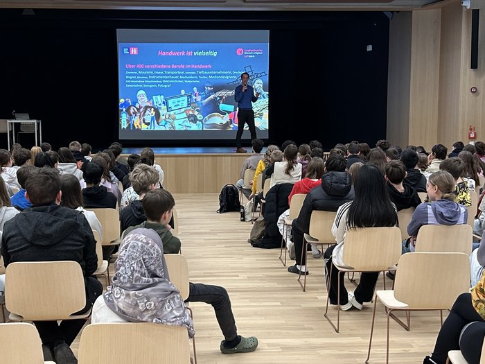 Einblick in die praktischen Berufe in Sterzing Viele Schüler hören einem Vortrag über verschiedene Berufe im Handwerk zu