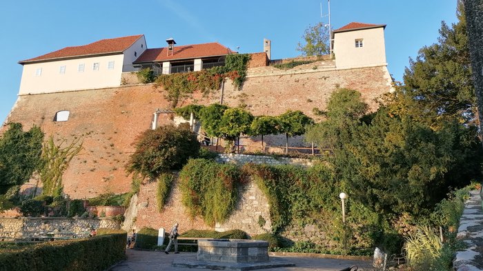 Unsere Althandwerker zu Besuch in der Stiermark Historische Burg mit roten Ziegeldächern und bewachsenen Mauern bei klarem Himmel