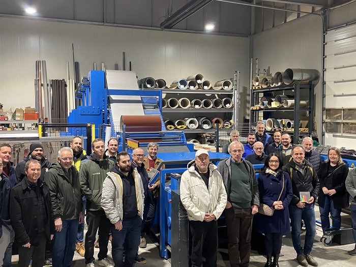 Zukunftsorientierte Themen bei der Ortsversammlung in Latsch Gruppenfoto von Erwachsenen in einer Werkstatt vor Maschinen und Materialregalen