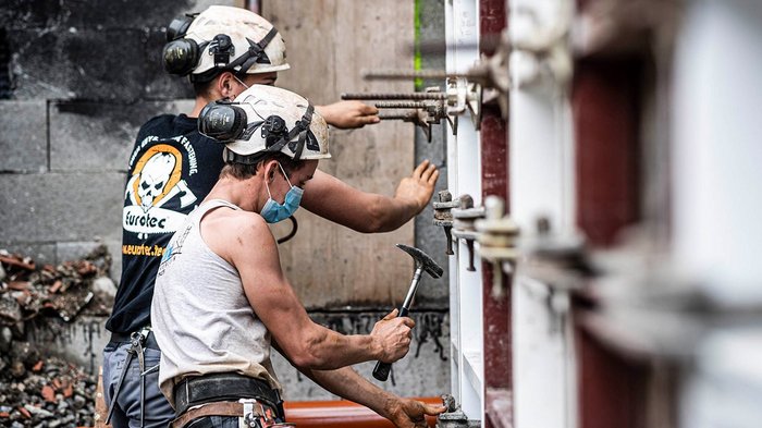 Raumordnungsgesetz: lvh hofft auf schnelle Durchführungsbestimmungen Zwei Bauarbeiter mit Helmen bei Montagearbeiten auf der Baustelle