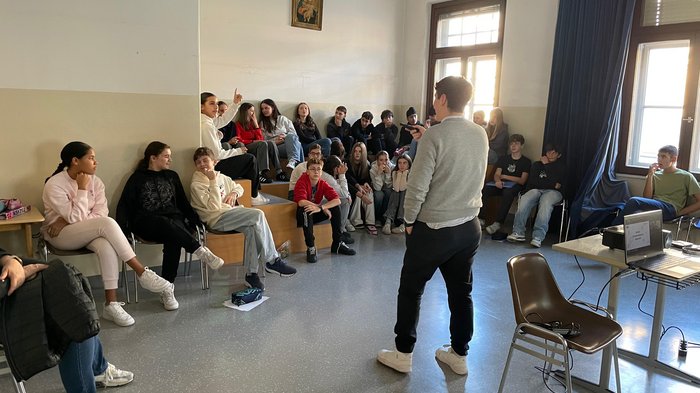 Eintauchen in die Welt der Berufe Junger Mann hält Vortrag vor einer Gruppe von Jugendlichen in einem Klassenraum