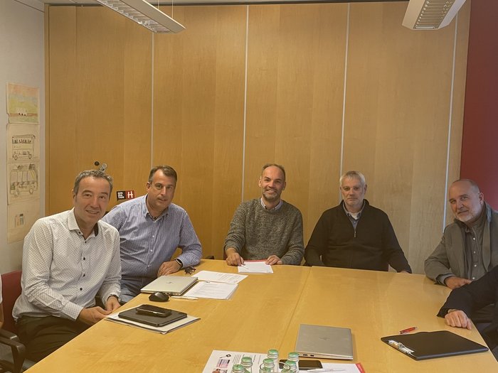 Südtiroler Transportbranche: mit vereinten Kräften unterwegs Sieben Personen in einem Meetingraum um einen Konferenztisch sitzend