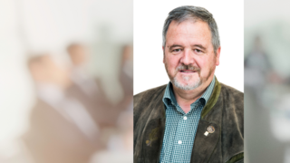 News Porträt eines lächelnden Mannes mit kariertem Hemd und Trachtenjacke