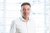 Home Porträt eines Mannes in weißem Hemd vor hellen Fenstern