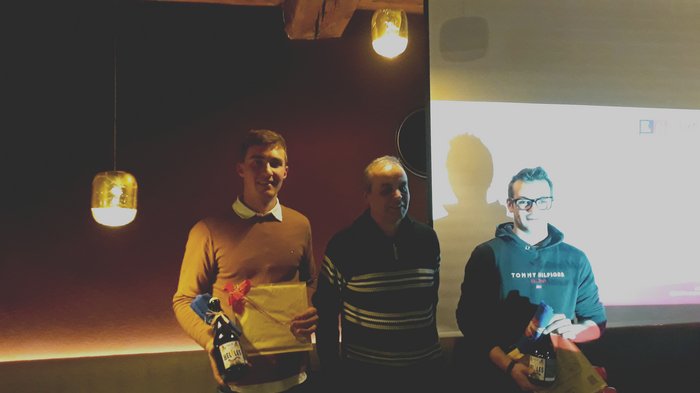 Dankesessen der Zimmerer Drei Männer bei einer kleinen Feier mit Geschenken und Getränken in dunklem Raum