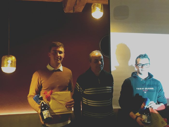 Dankesessen der Zimmerer Drei Männer bei einer kleinen Feier mit Geschenken und Getränken in dunklem Raum