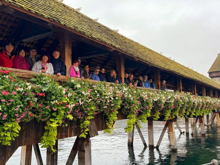Herbstreise der Althandwerker/innen im lvh: Schweizer Genuss und Panorama pur Menschen auf der historischen Kapellbrücke mit Blumen in Luzern