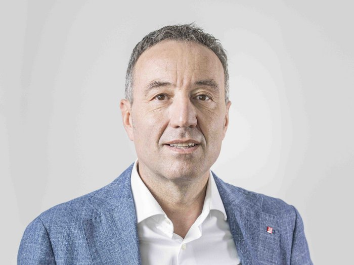 Sicurezza sul lavoro: una priorità strategica per l’artigianato altoatesino Ritratto di uomo con giacca blu e camicia bianca su sfondo bianco