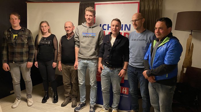 Zahlreiche Projekte in Villanders Sieben Personen stehen nebeneinander vor Bannern in einem Raum