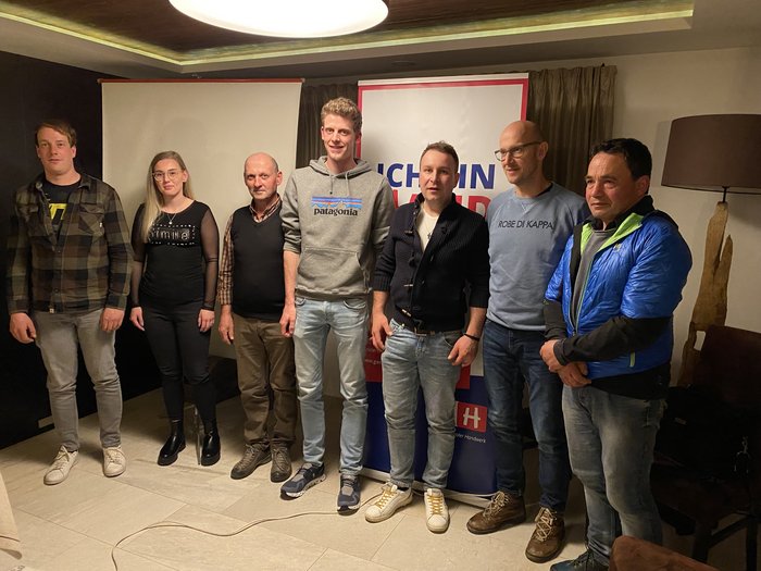 Zahlreiche Projekte in Villanders Sieben Personen stehen nebeneinander vor Bannern in einem Raum