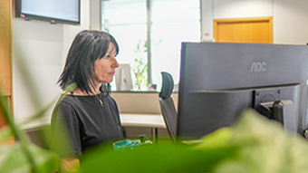 Home Donna che lavora concentrata al computer in ufficio