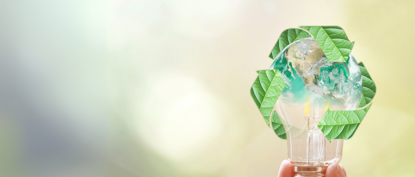 Diritto ambientale Mano tiene lampadina con la Terra e simbolo di riciclo fatto di foglie verdi