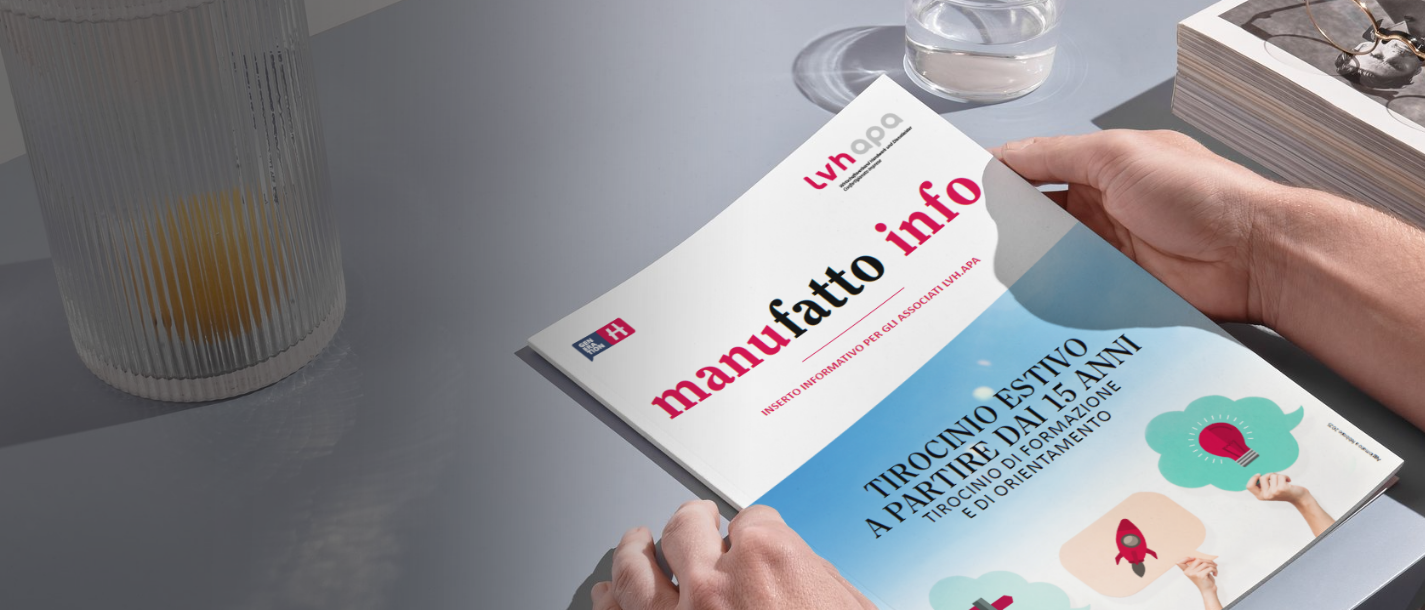 Tirocini estivi Persona che tiene la rivista manufatto info su tavolo grigio con candela e bicchiere