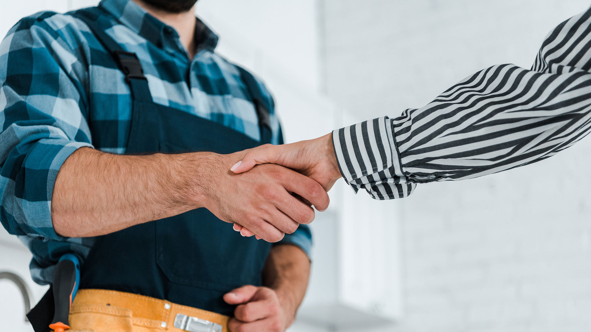 Home Stretta di mano tra operaio e persona in abbigliamento formale