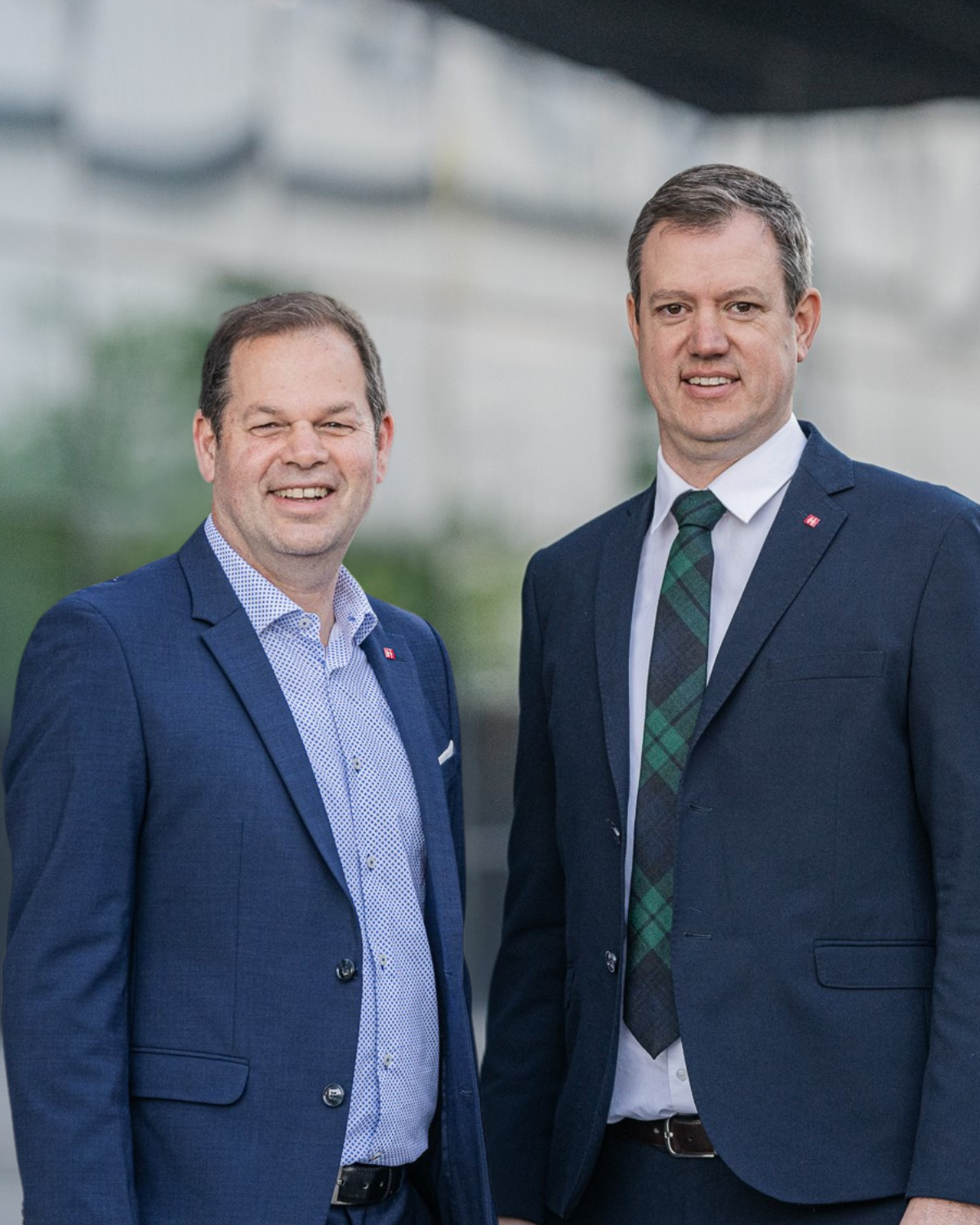 Südtirol: Meisterbrief ist dem Bachelor gleichgestellt Zwei Männer in Anzügen lächelnd vor einem Gebäude